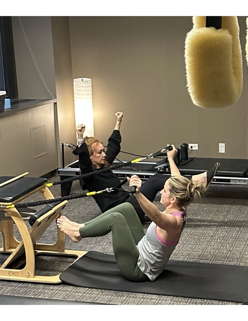Two clients training side by side with their coach in a small-group session